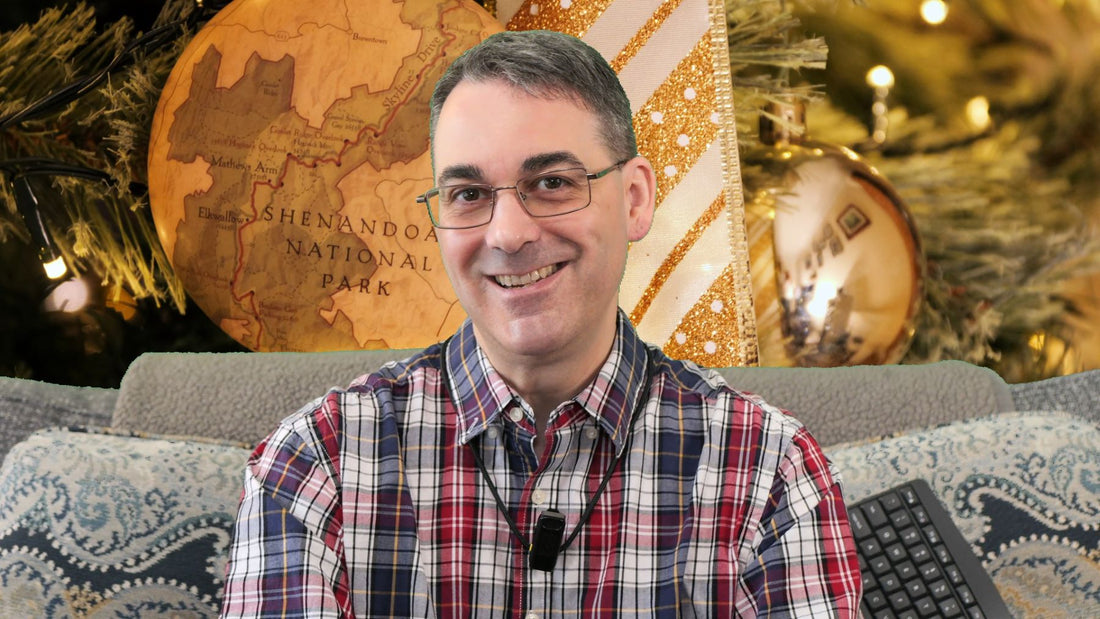 The author is sitting in front of an enlarged photo of a Shenandoah National Park ornament on a Christmas tree.